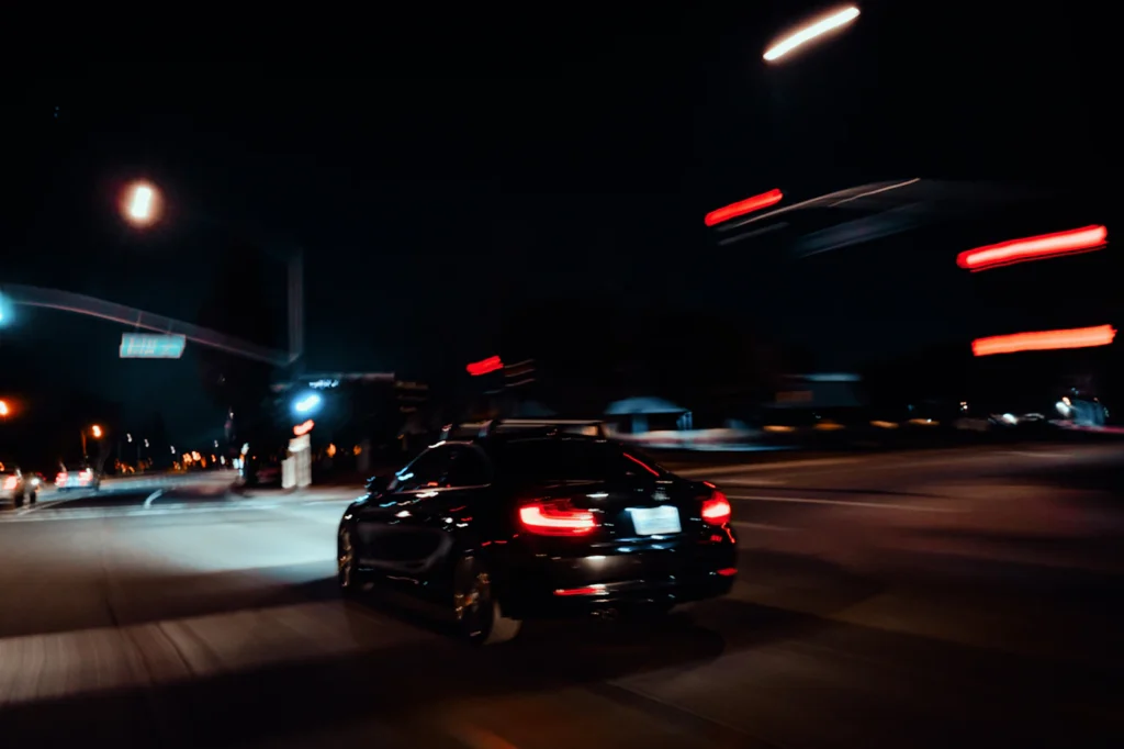 Car driving through town at night for late delivery until 11 PM